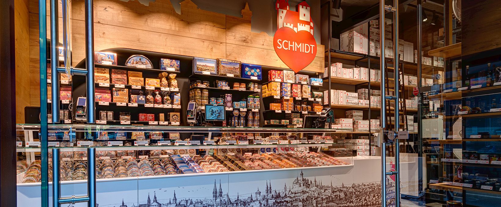 Verkäuferin übergibt Tasche mit gekauften Lebkuchen-Schmidt Produkten an Käuferin